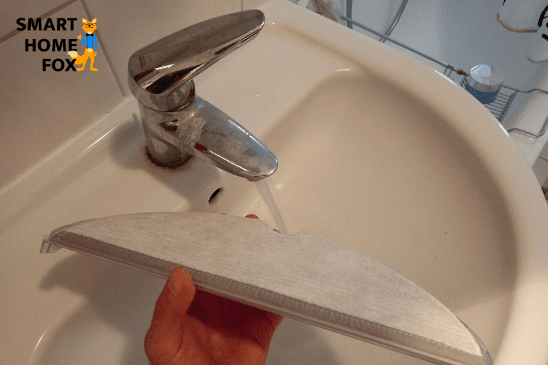 Wischmopp des Roborock S6 MaxV wird unter dem Wasserhahn befeuchtet.